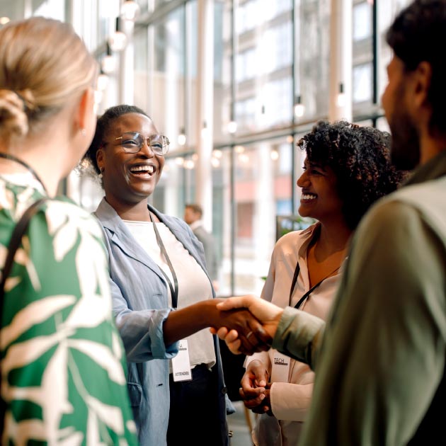 Happy business professionals laughing while interacting with each other during seminar at convention center
