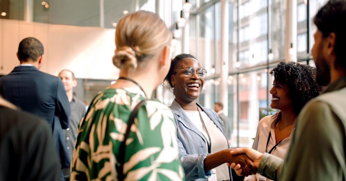 Happy business professionals laughing while interacting with each other during seminar at convention center