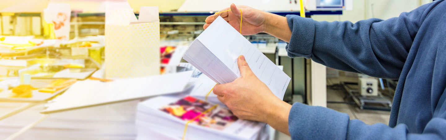 person holding stack of paper