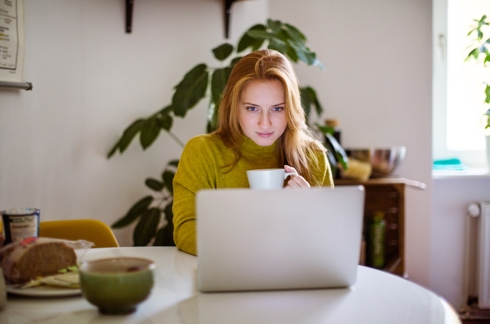 Person on laptop watching a DonorPerfect Recorded Webinar