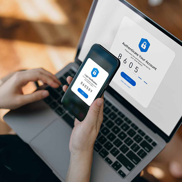 A person using 2 factor authentication on their laptop and their phone.
