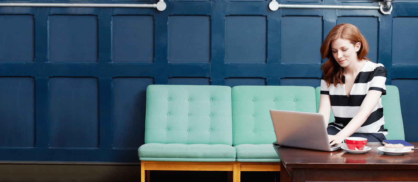 Woman working with DonorPerfect on a couch