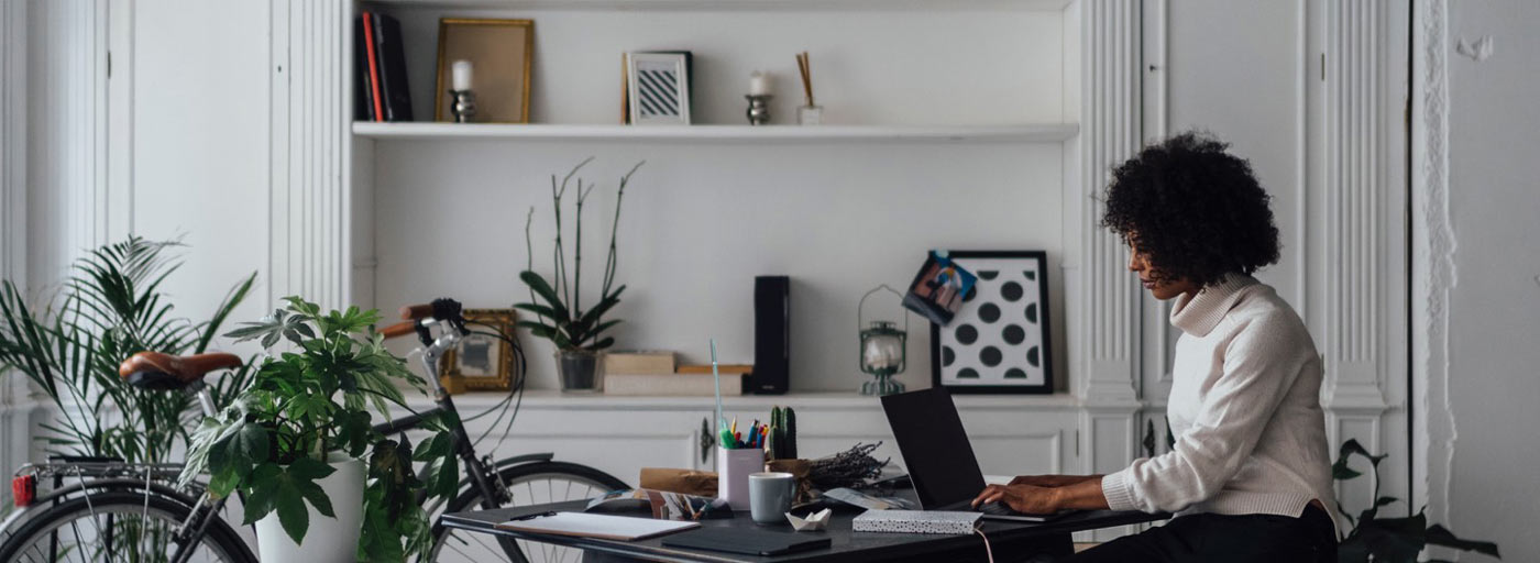 DonorPerfect Online Forms Hero: Lady sitting at desk on computer