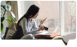 Woman looking at phone and holding credit card